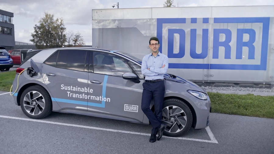 Photo: Dürr: A man standing in front of a car